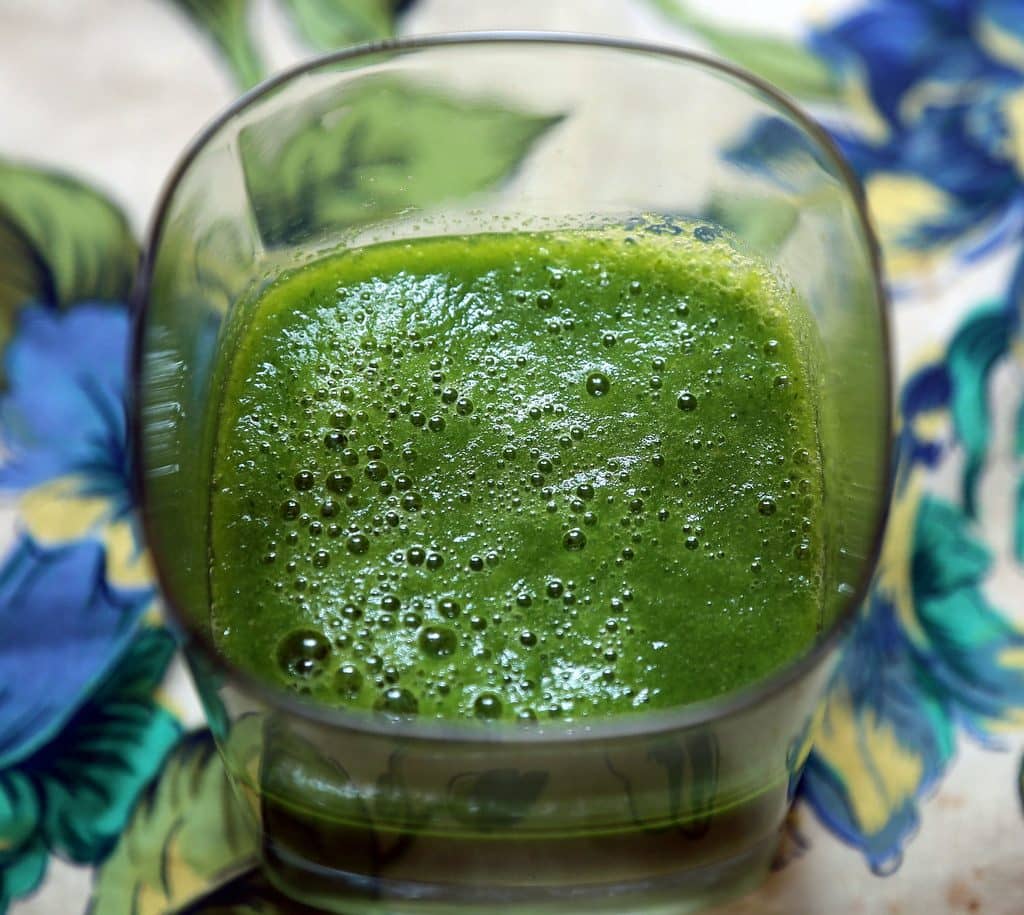 A vibrant green smoothie in a glass